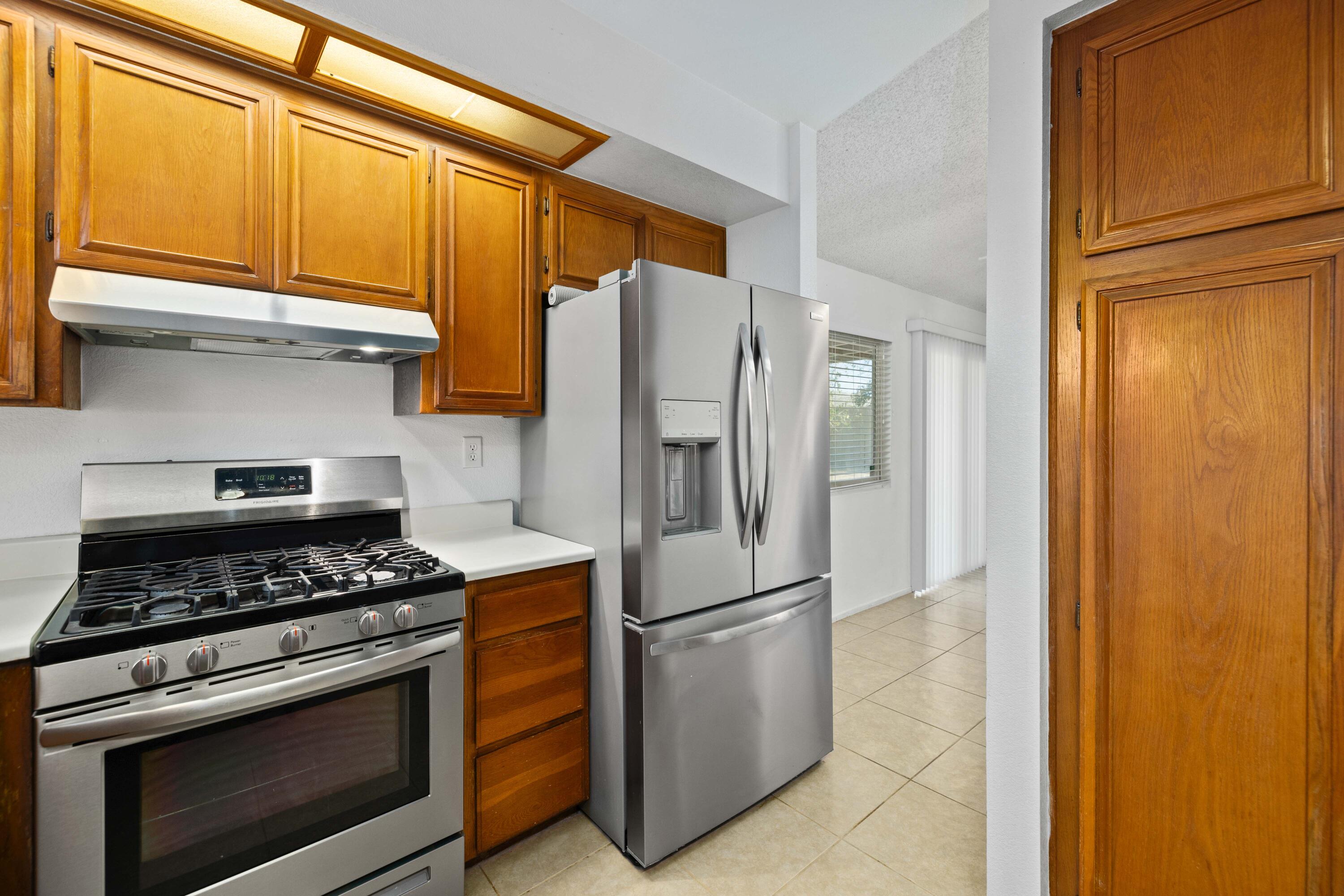 3043 Echo Drive Rosamond, CA 93560 - Photo 8 of 24 a kitchen with stainless steel appliances granite countertop a refrigerator stove and cabinets