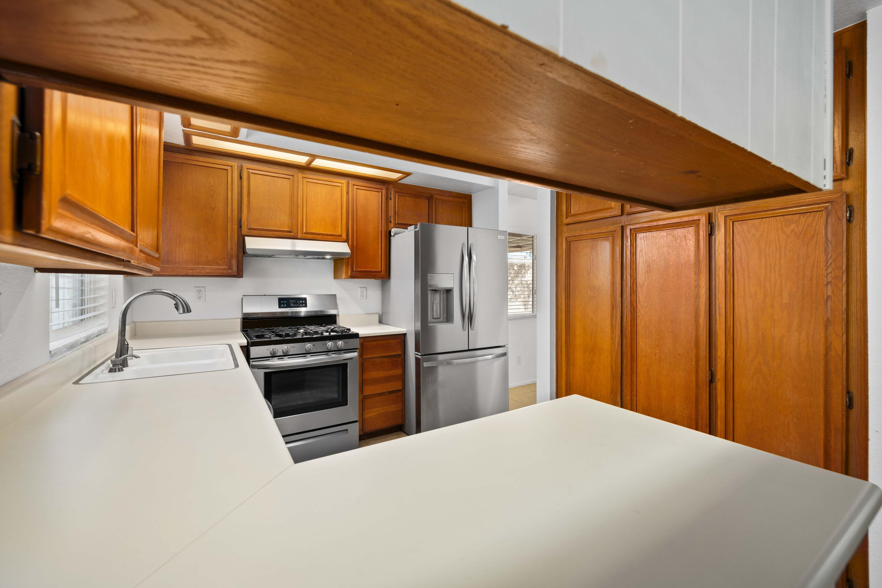 3043 Echo Drive Rosamond, CA 93560 - Photo 9 of 24 a kitchen with a refrigerator a stove top oven a sink and dishwasher