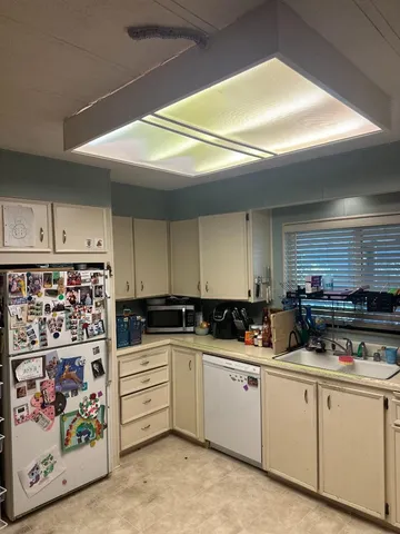 a kitchen with appliances a sink and cabinets