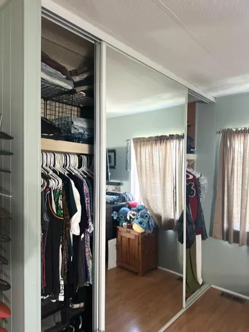 a view of walk in closet with clothes and shoes