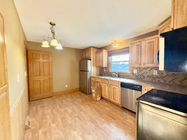 a kitchen with granite countertop a sink cabinets and stainless steel appliances