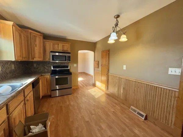 a kitchen with granite countertop a refrigerator and a stove top oven