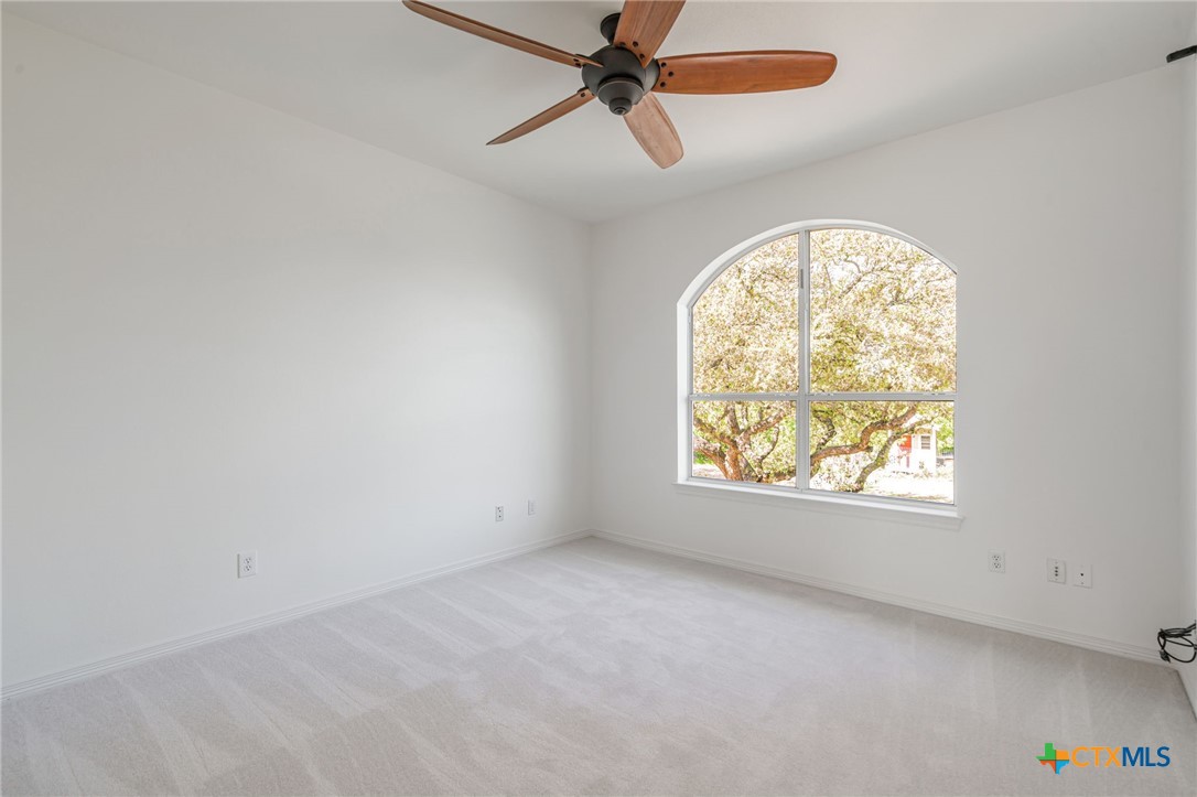 200 Tovas Secret Cove Georgetown, TX 78628 - Photo 20 of 31 an empty room with windows and a ceiling fan