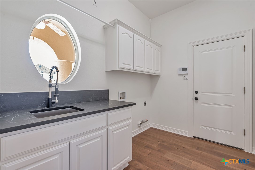 200 Tovas Secret Cove Georgetown, TX 78628 - Photo 25 of 31 a kitchen with cabinets and a wooden floor