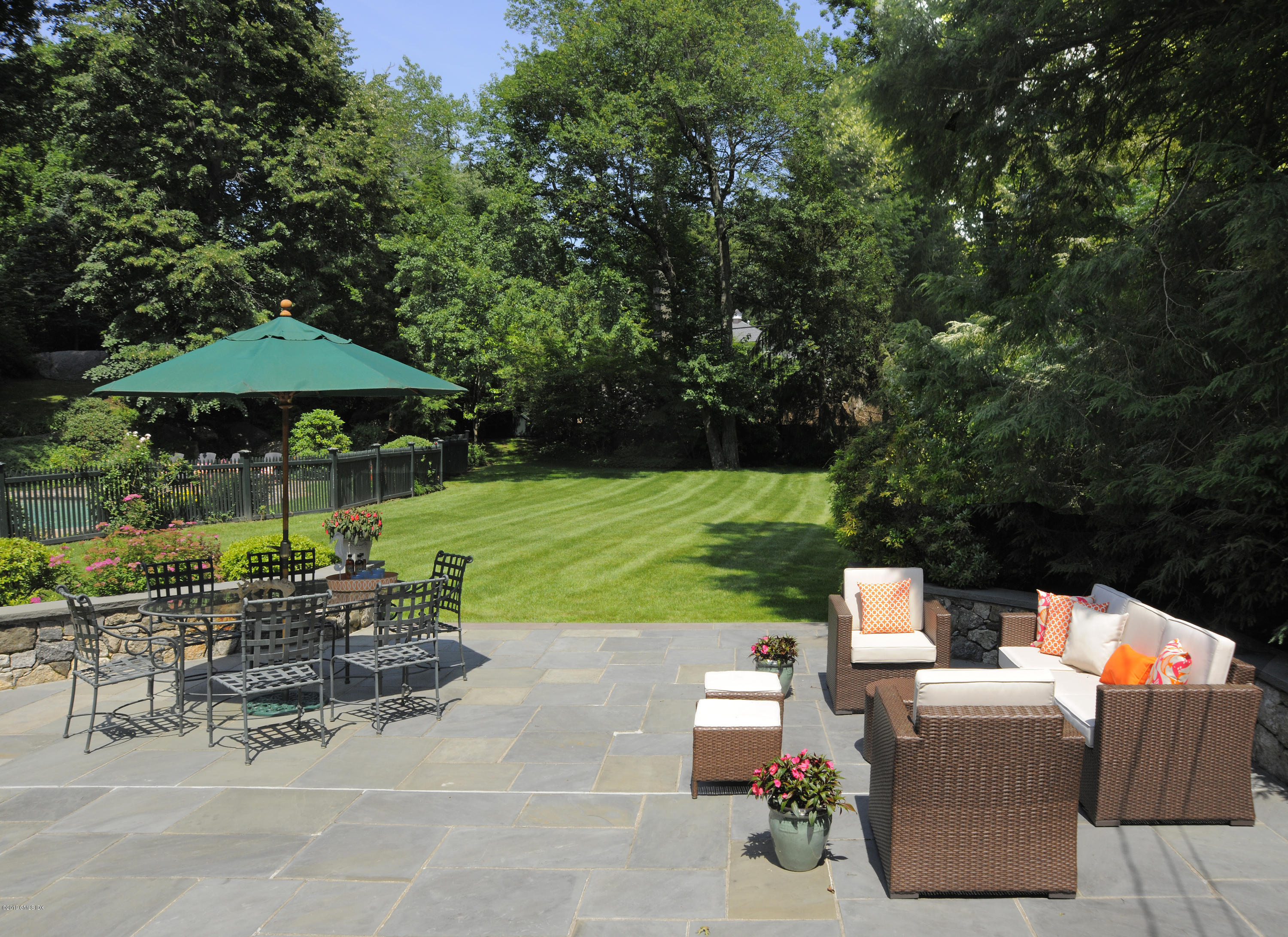 35 Copper Beech Road Greenwich, CT 06830 - Photo 18 of 26 a view of a table and chairs under an umbrella