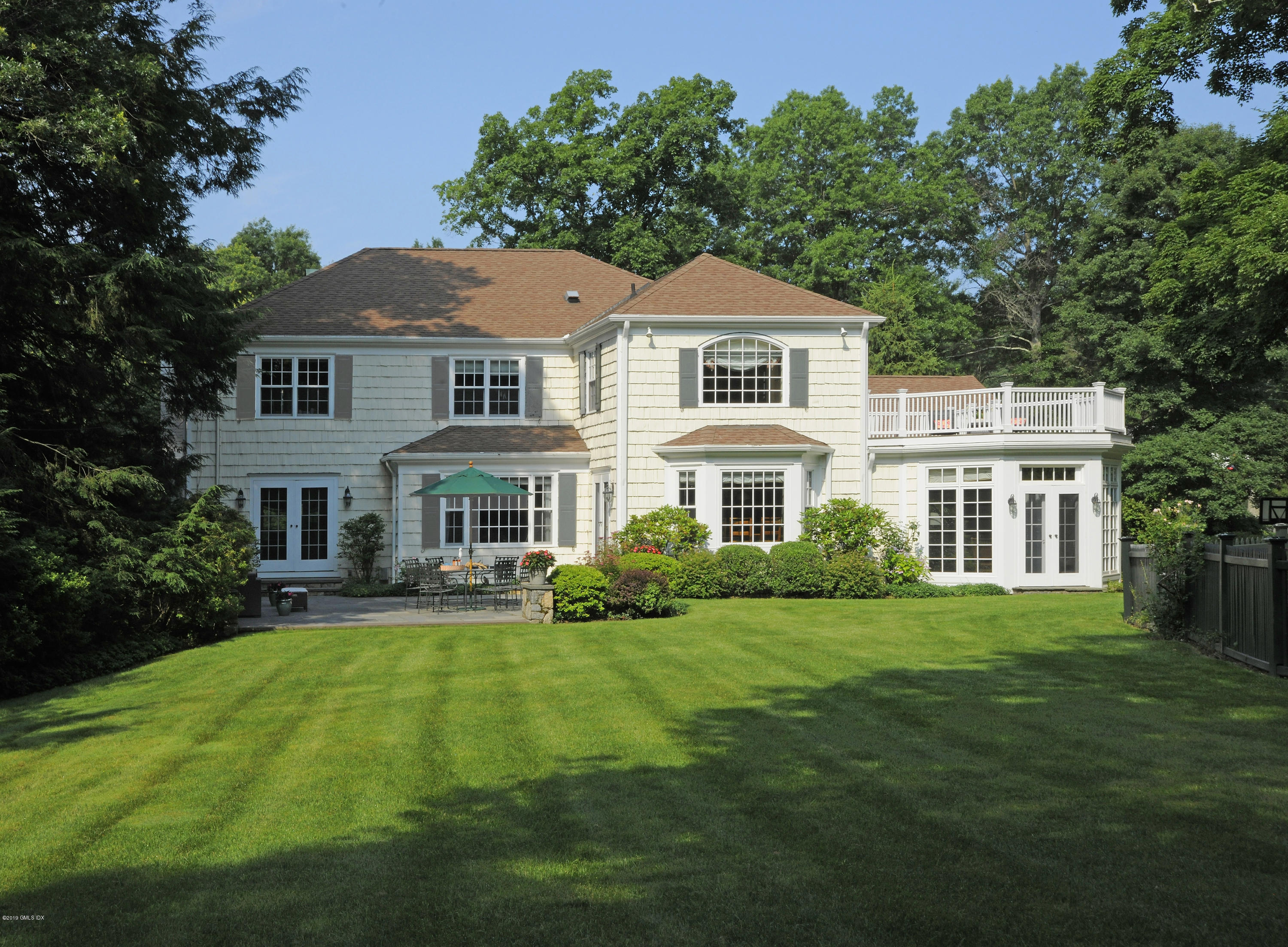 35 Copper Beech Road Greenwich, CT 06830 - Photo 23 of 26 a front view of a house with a yard table and chairs