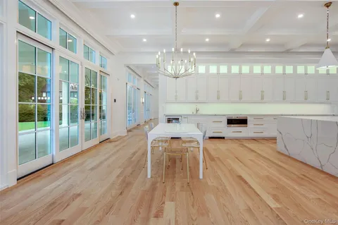 a view of a dining room with furniture a chandelier and wooden floor