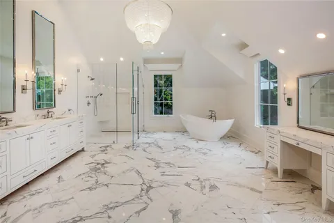 a large bathroom with a sink mirror and a bath tub sitting next to a window
