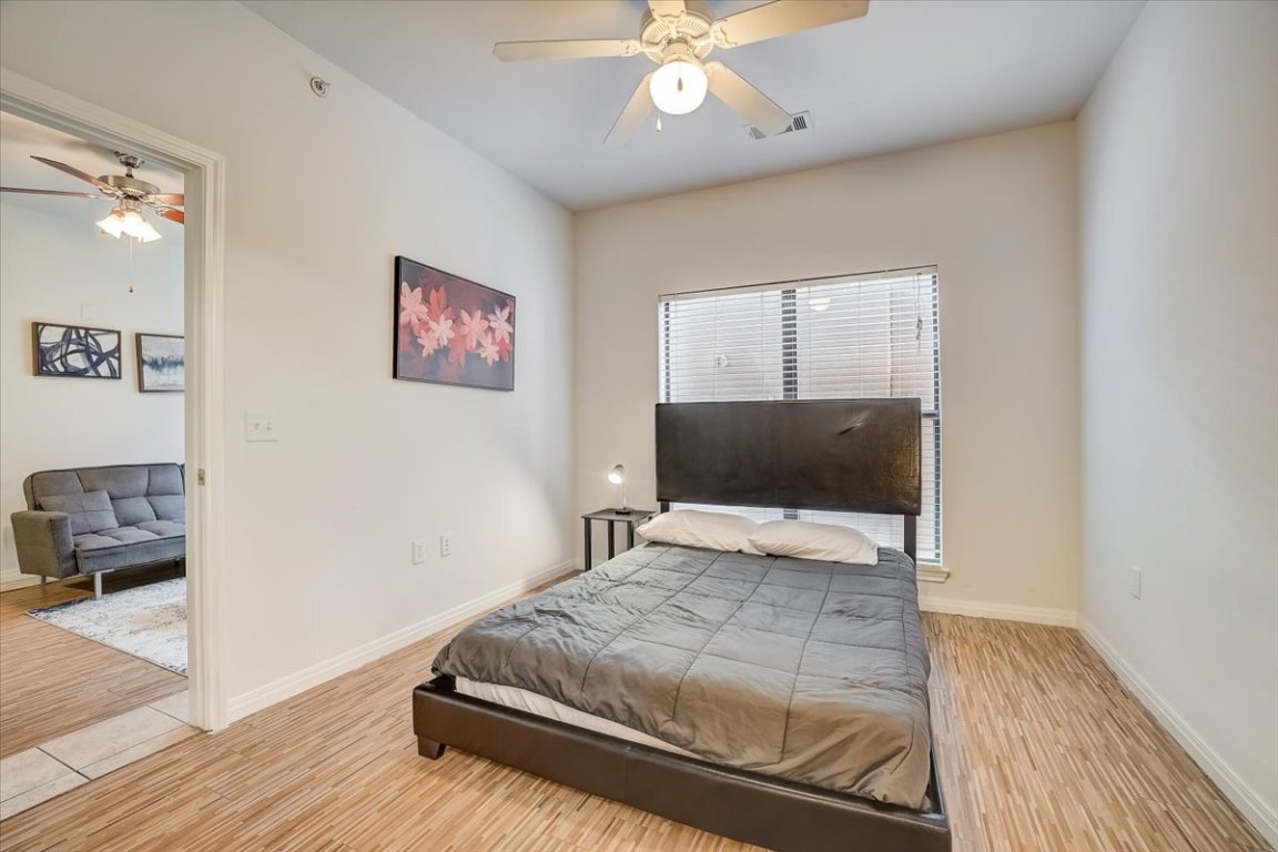 2515 Pearl Street, Unit 212 Austin, TX 78705 - Photo 6 of 10 a bedroom with a bed and a flat screen tv