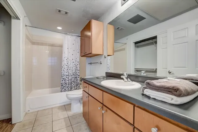 a bathroom with a double vanity sink toilet and shower