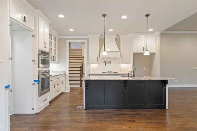 a large kitchen with granite countertop a stove and a sink
