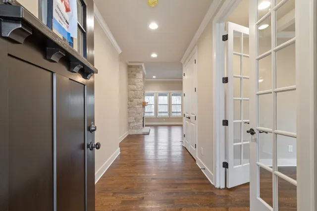 an empty room with wooden floor fireplace and windows