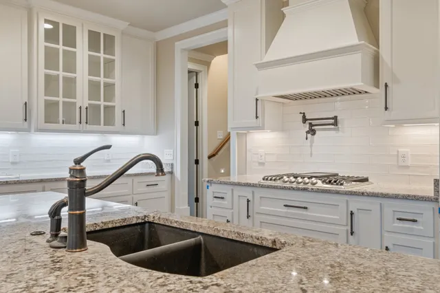 a kitchen with stainless steel appliances granite countertop a sink a stove and a refrigerator