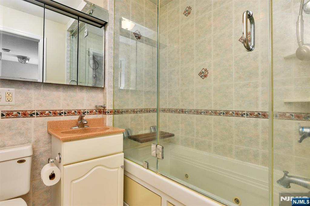 32 Washburn Place, Unit 1 Caldwell, NJ 07006 - Photo 14 of 16 a bathroom with a sink a mirror and a shower