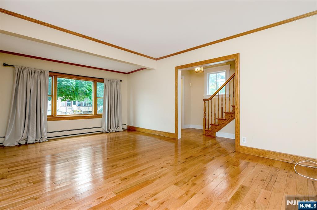 32 Washburn Place, Unit 1 Caldwell, NJ 07006 - Photo 2 of 16 a view of an empty room with wooden floor and a window