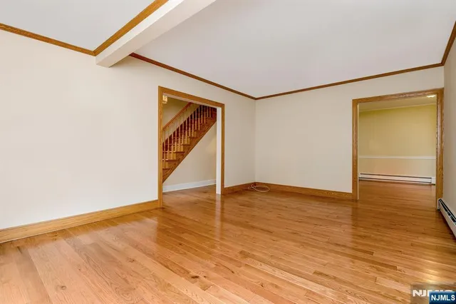a view of an empty room with wooden floor