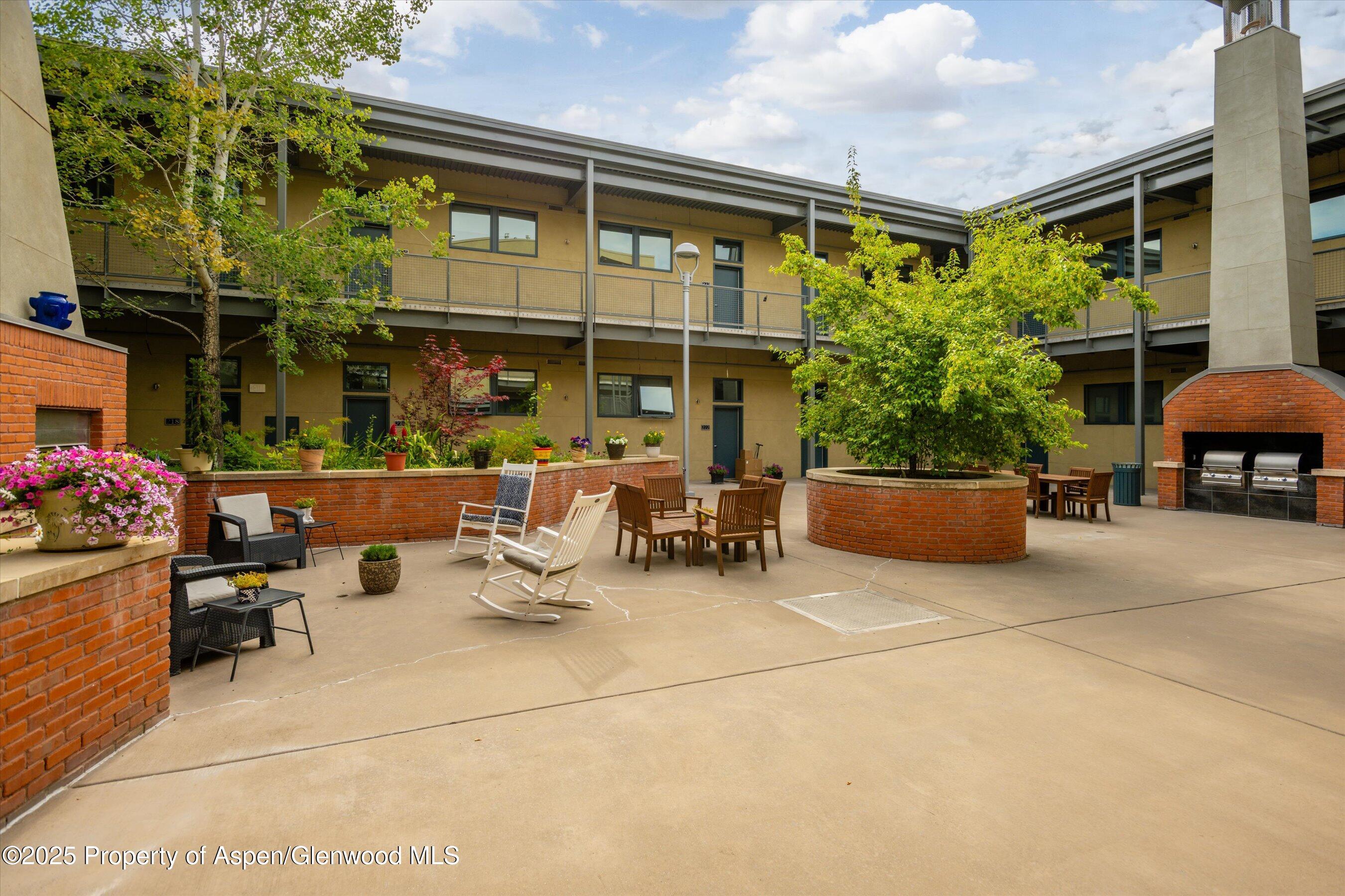 361 Robinson Street, Unit 308 Basalt, CO 81621 - Photo 13 of 23 a view of a patio with dining table and chairs and potted plants