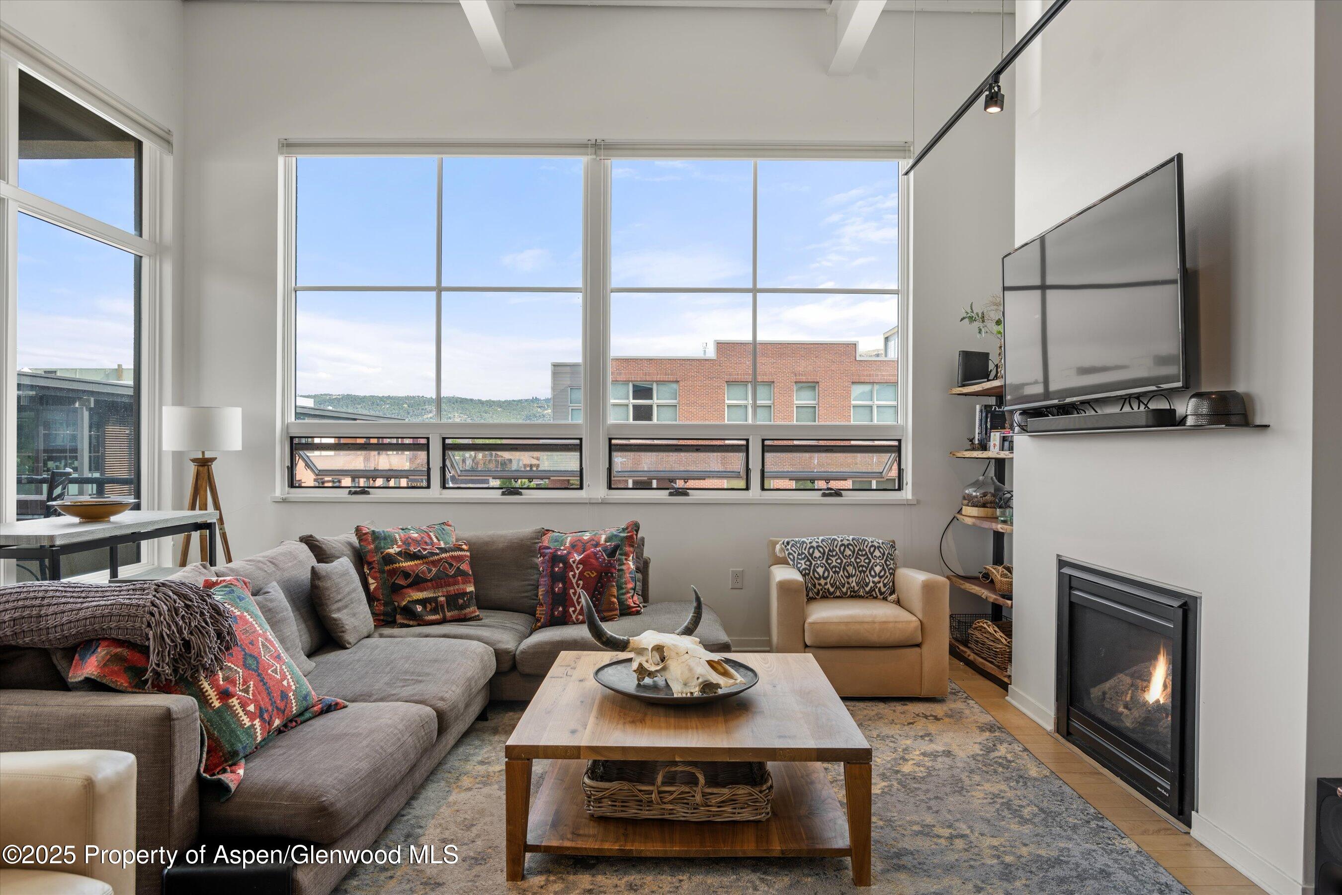 361 Robinson Street, Unit 308 Basalt, CO 81621 - Photo 5 of 23 a living room with furniture a flat screen tv and a fireplace