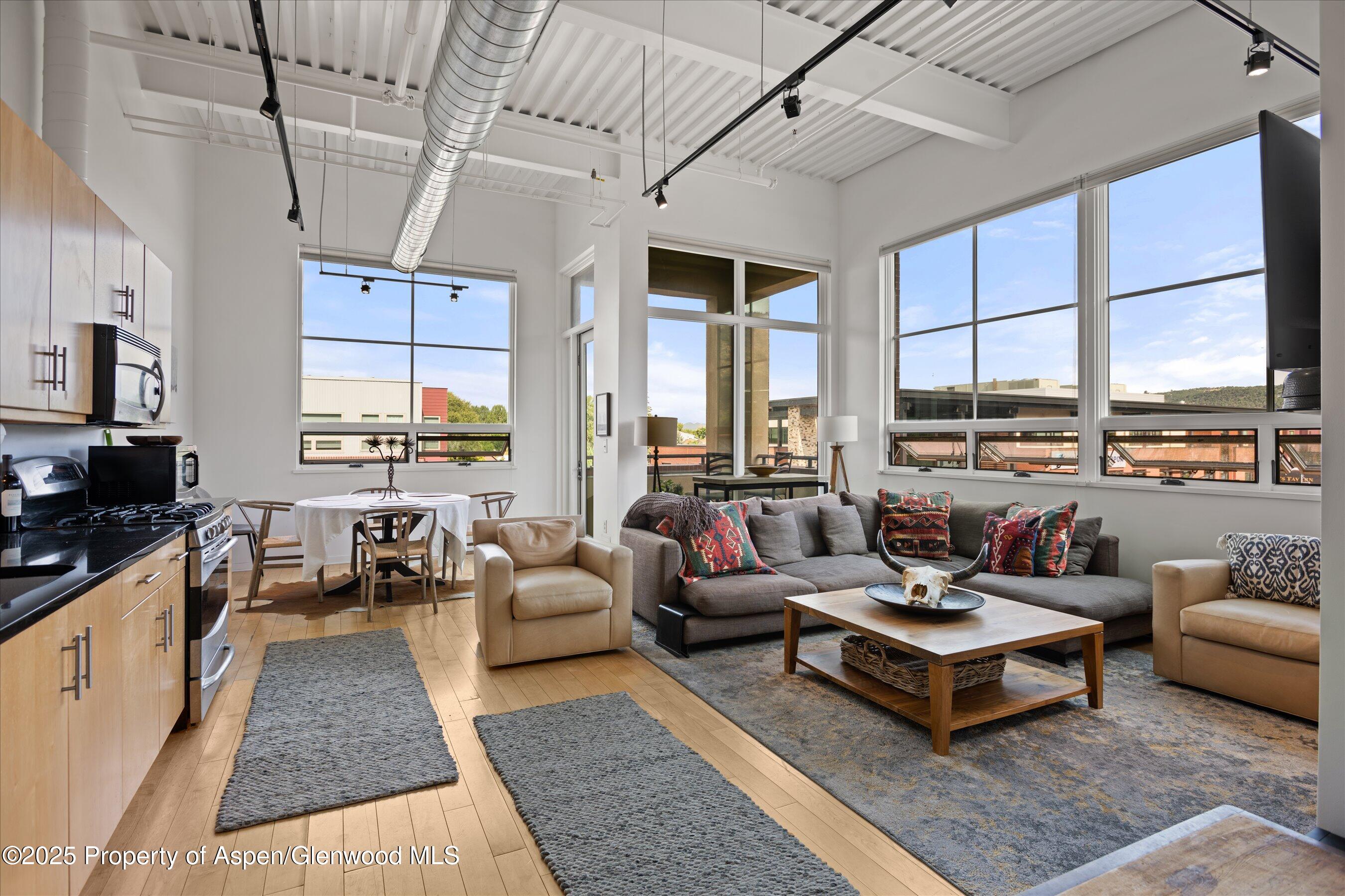 361 Robinson Street, Unit 308 Basalt, CO 81621 - Photo 7 of 23 a living room with furniture large windows and wooden floor