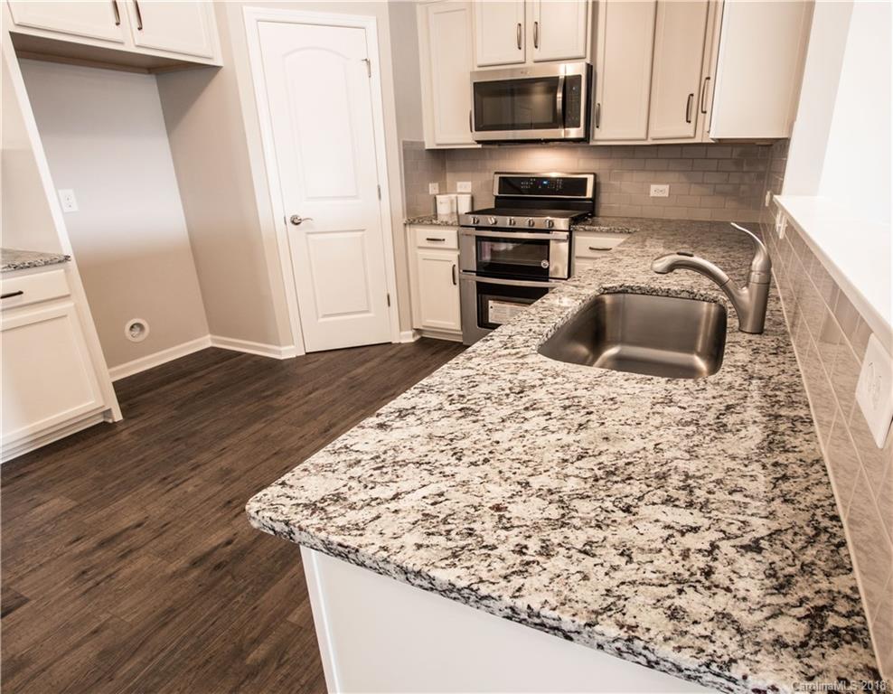 1889 Larkspur Way Tega Cay, SC 29708 - Photo 11 of 29 a kitchen with granite countertop a sink and a stove top oven