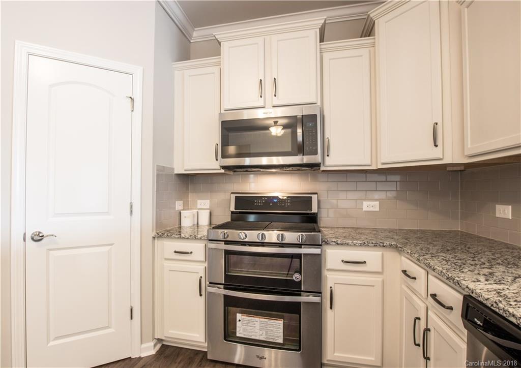1889 Larkspur Way Tega Cay, SC 29708 - Photo 13 of 29 a kitchen with granite countertop cabinets stainless steel appliances and wooden cabinets