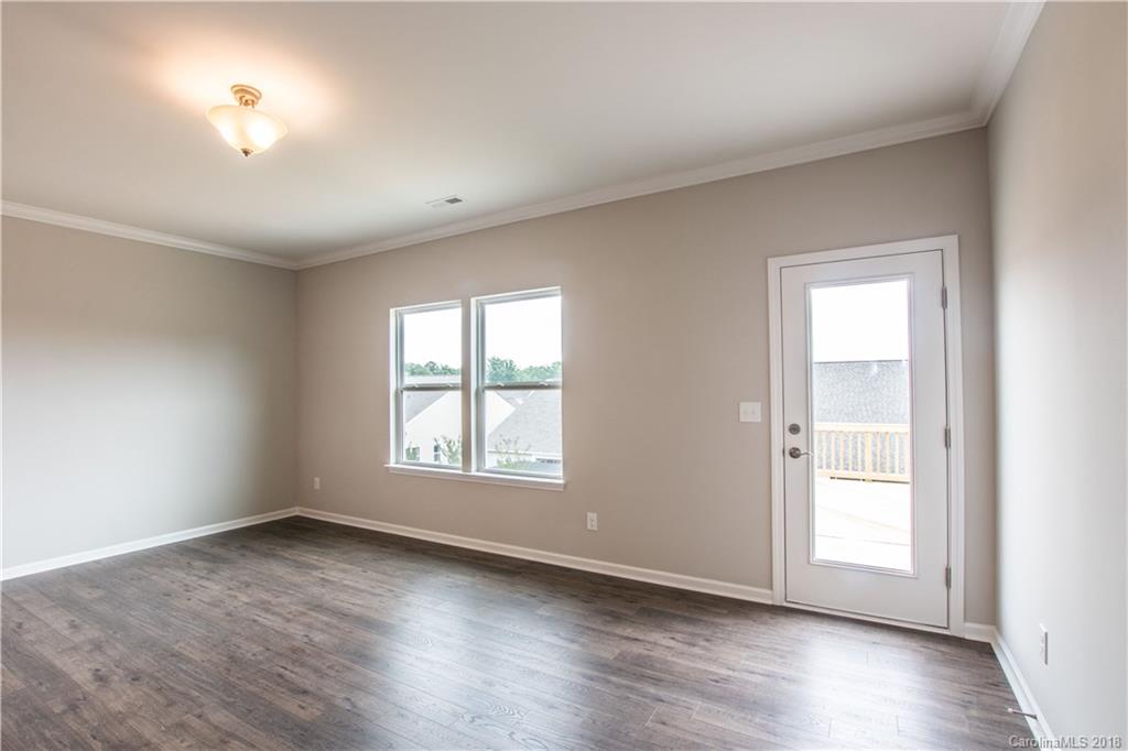 1889 Larkspur Way Tega Cay, SC 29708 - Photo 19 of 29 an empty room with wooden floor and windows