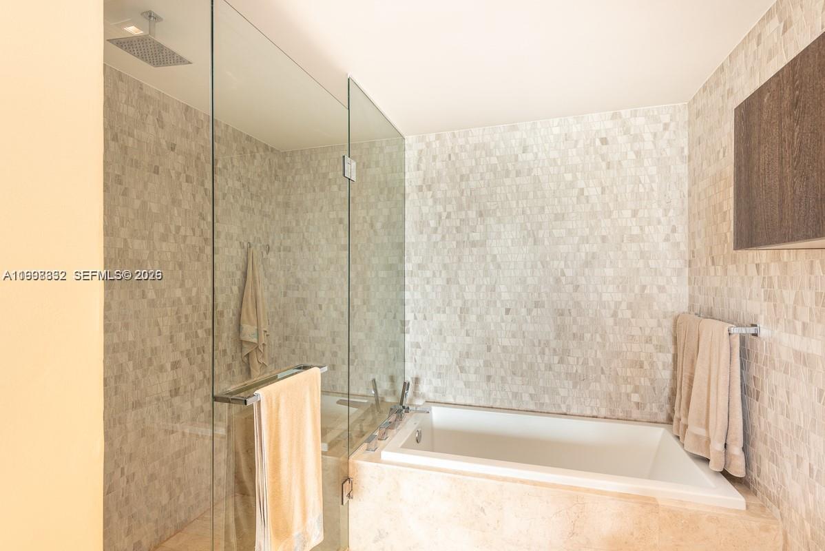 68 Southeast 6th Street, Unit 3006 Miami, FL 33131 - Photo 6 of 10 a bathroom with a bathtub and a shower
