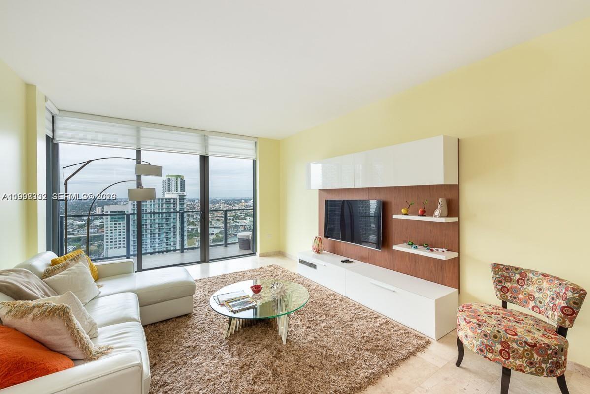 68 Southeast 6th Street, Unit 3006 Miami, FL 33131 - Photo 8 of 10 a living room with furniture and a fireplace