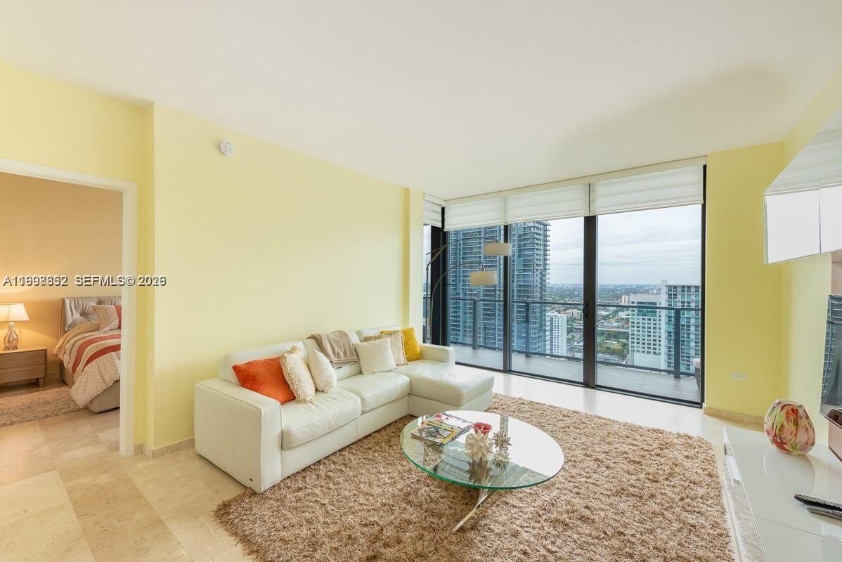 68 Southeast 6th Street, Unit 3006 Miami, FL 33131 - Photo 9 of 10 a living room with furniture and a table