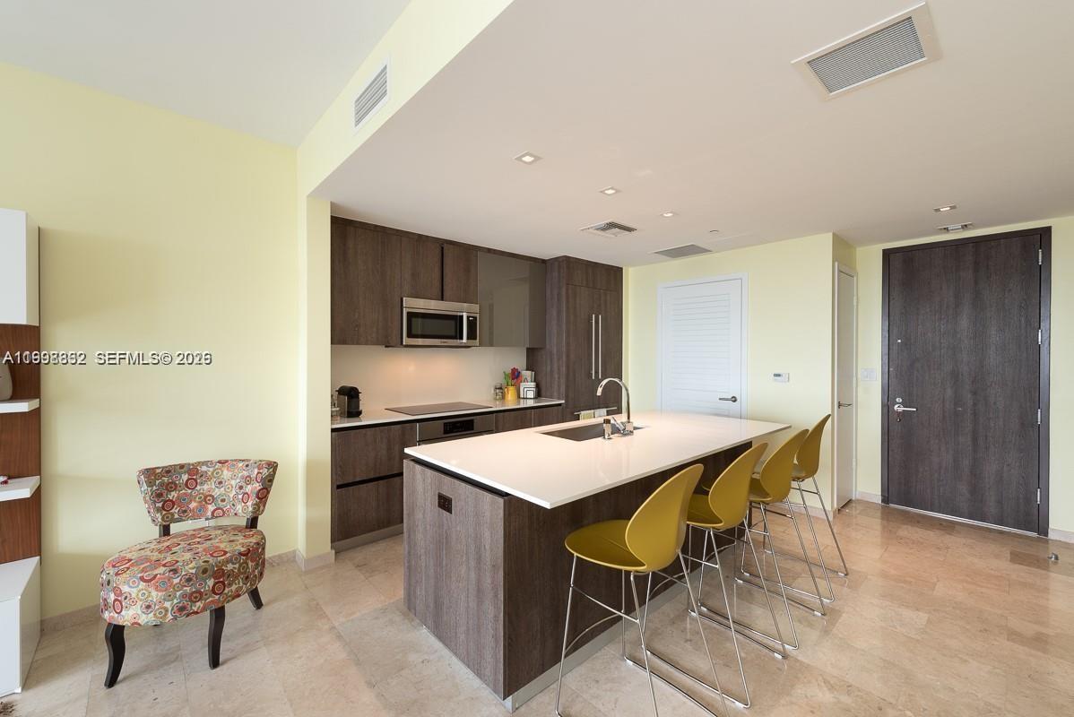 68 Southeast 6th Street, Unit 3006 Miami, FL 33131 - Photo 10 of 10 a large kitchen with a table and chairs in it