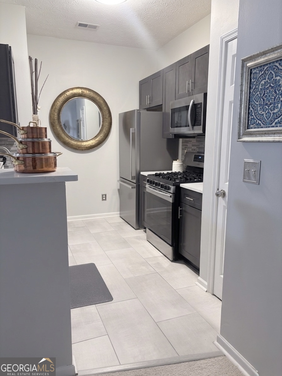 2851 Walden Lake Bend Decatur, GA 30035 - Photo 5 of 17 a kitchen with stainless steel appliances granite countertop a stove a sink and a refrigerator
