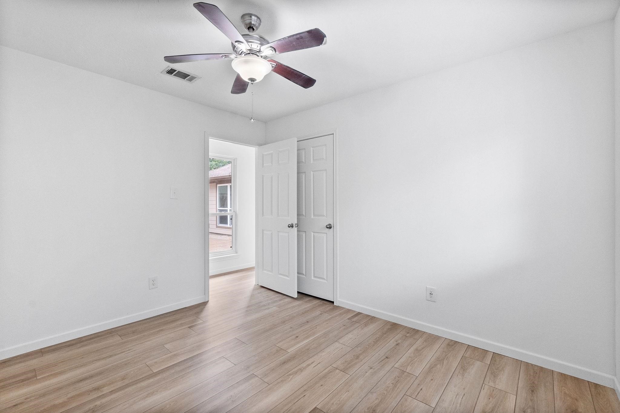 21710 Glenbranch Drive Spring, TX 77388 - Photo 21 of 32 an empty room with wooden floor and a ceiling fan