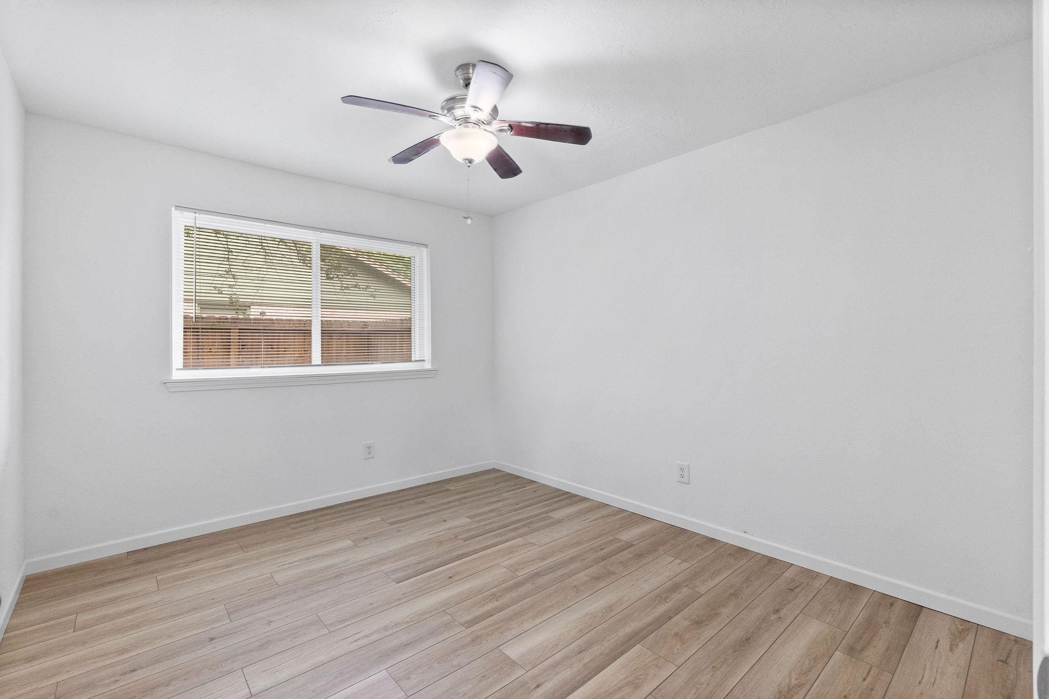 21710 Glenbranch Drive Spring, TX 77388 - Photo 22 of 32 a view of an empty room with wooden floor and a window