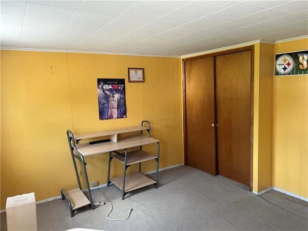 a bedroom with a bed and a flat tv screen on dresser