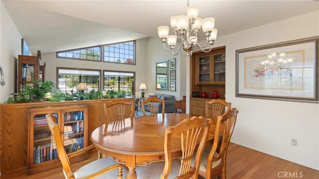a dining room with furniture a large window and wooden floor