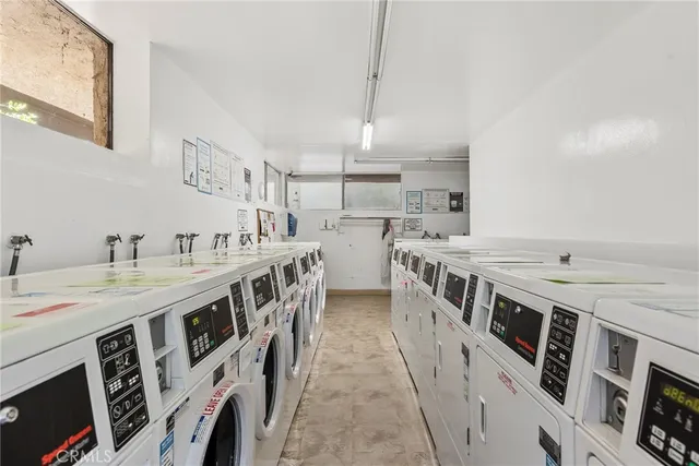 a kitchen with stainless steel appliances granite countertop a white stove top oven a sink dishwasher and white cabinets with wooden floor