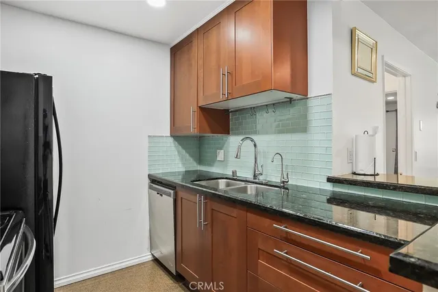 a kitchen with stainless steel appliances granite countertop a refrigerator and a sink