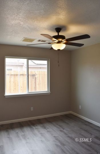 1405 Sims Street Ridgecrest, CA 93555 - Photo 8 of 12 an empty room with a window and a fan
