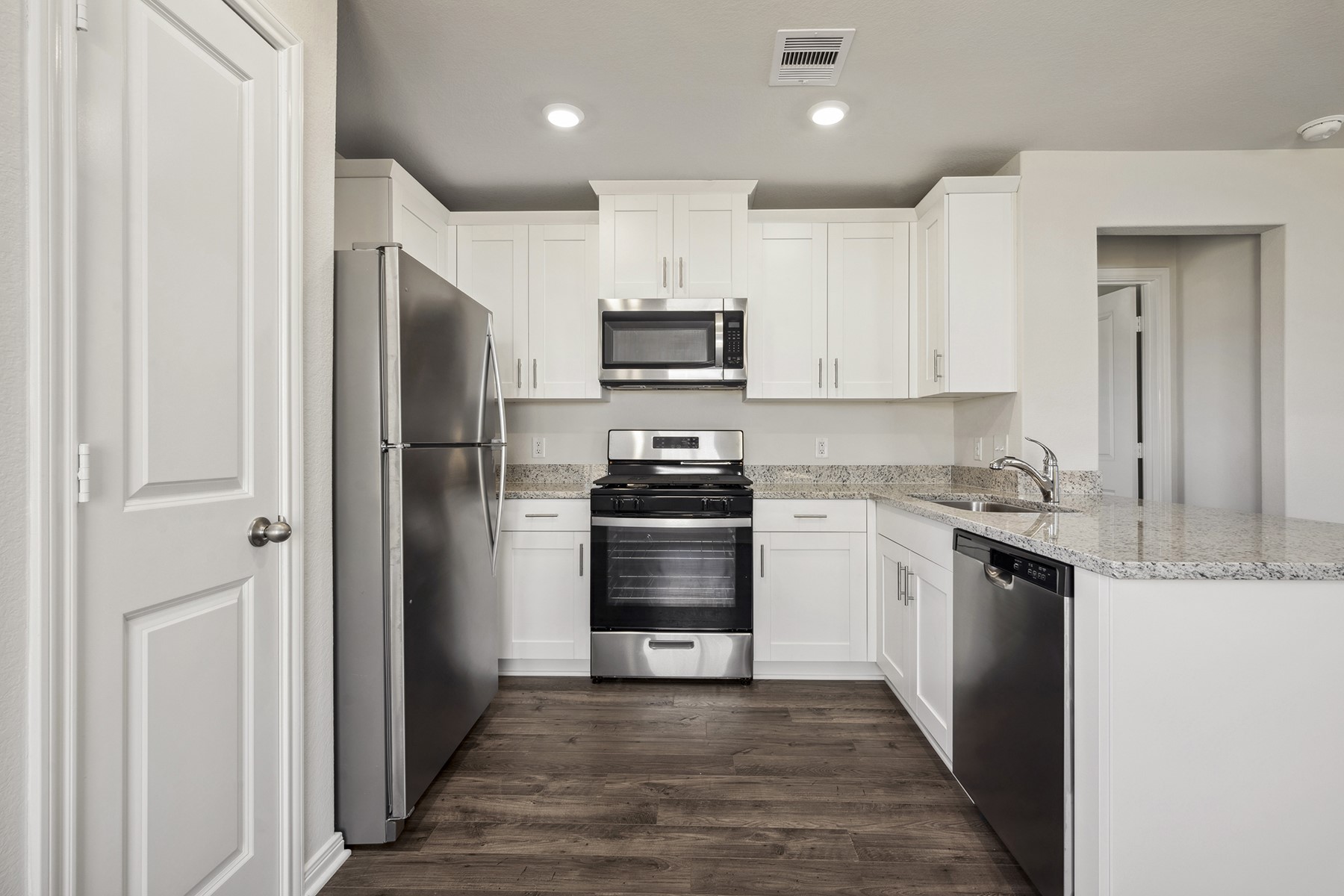 10430 Red Cardinal Drive Cleveland, TX 77328 - Photo 9 of 23 a kitchen with granite countertop white cabinets and stainless steel appliances