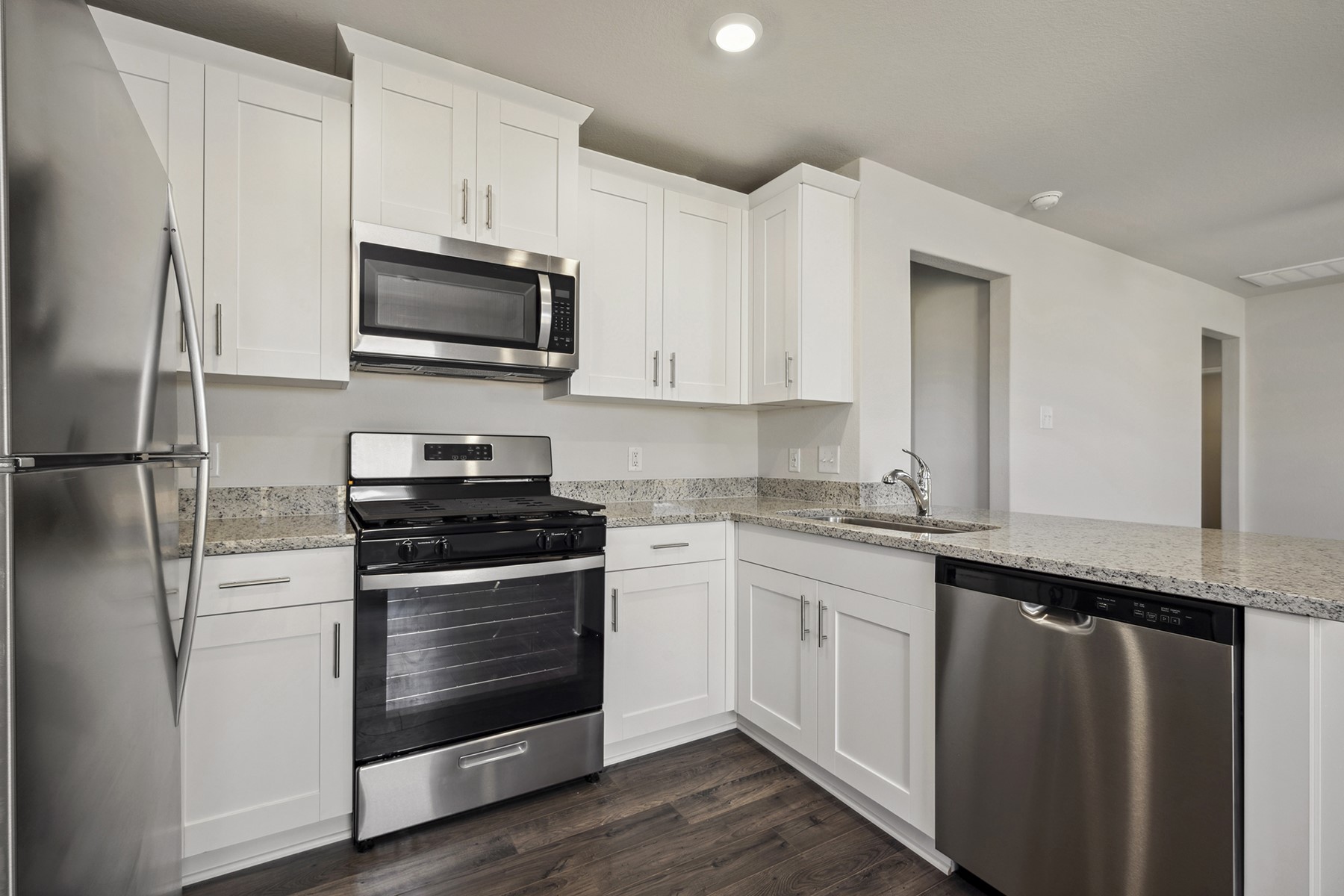10430 Red Cardinal Drive Cleveland, TX 77328 - Photo 10 of 23 a kitchen with stainless steel appliances granite countertop a stove a refrigerator and a microwave