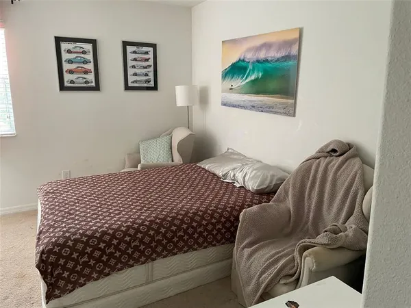 a bedroom with bed and a painting on the wall
