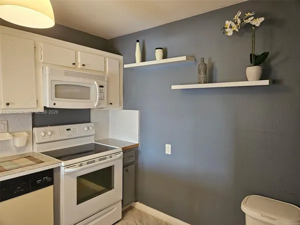 a kitchen with a stove cabinets and wooden floor