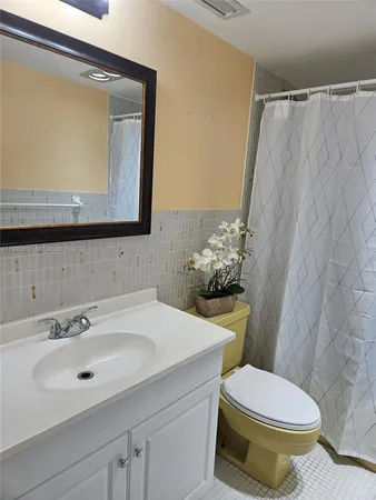 a bathroom with a sink mirror and toilet