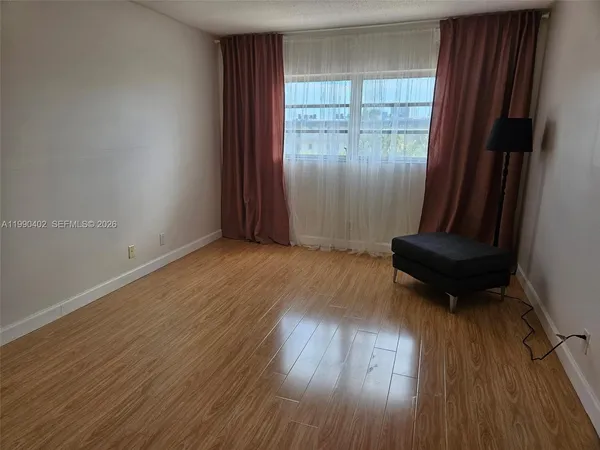 a view of a room with wooden floor and bench