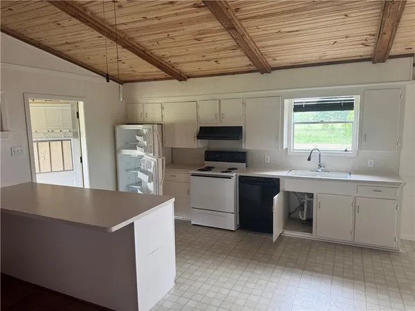 a kitchen with sink a microwave and cabinets