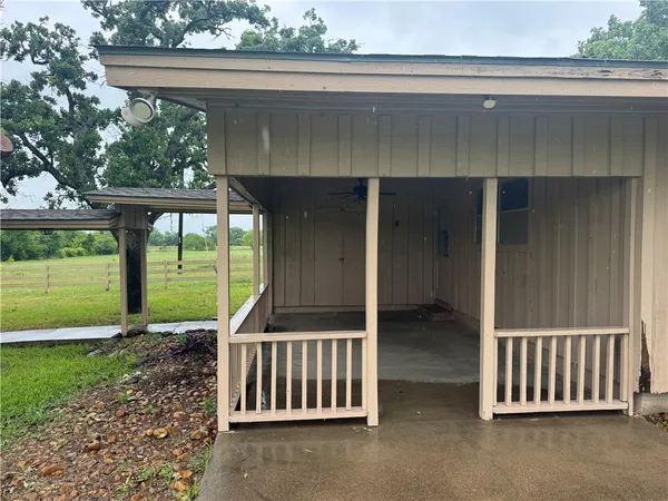 a view of a porch with a floor to ceiling window and yard