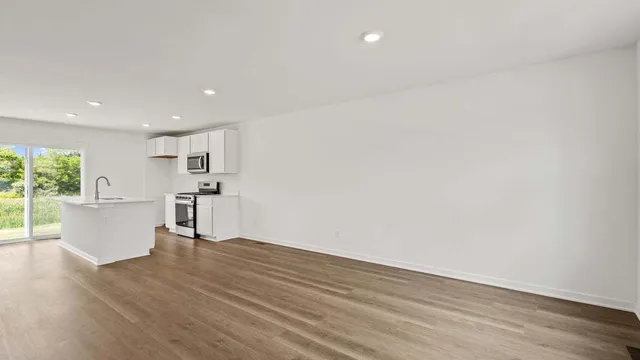 a view of kitchen with white cabinets and wooden floor