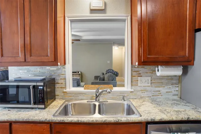 a kitchen with granite countertop a sink and cabinets