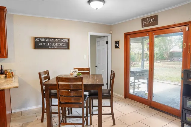 a dining room with furniture and large windows