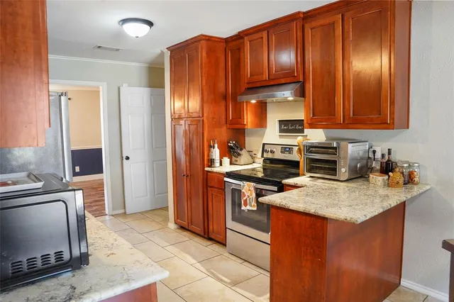 a kitchen with stainless steel appliances granite countertop a stove refrigerator sink and cabinets